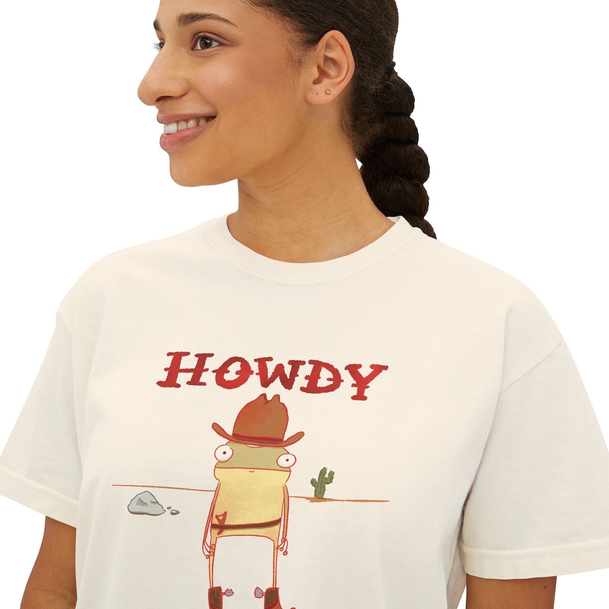 Person wearing a white t-shirt with a cartoon frog in a cowboy hat and 'HOWDY' text.