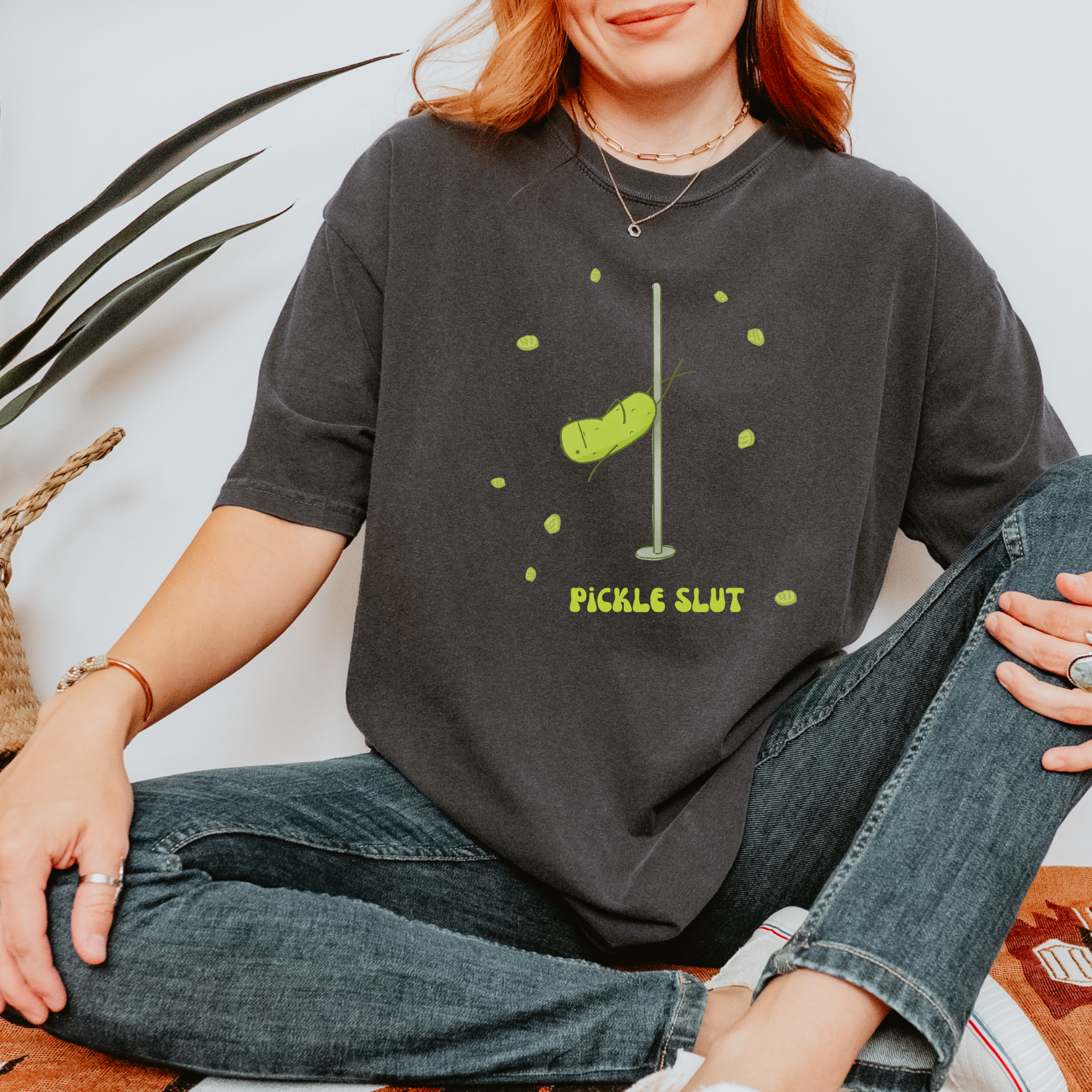 Relaxed fit unisex t-shirt with a funny illustration of a pole-dancing pickle and bold text that says 'Pickle Slut