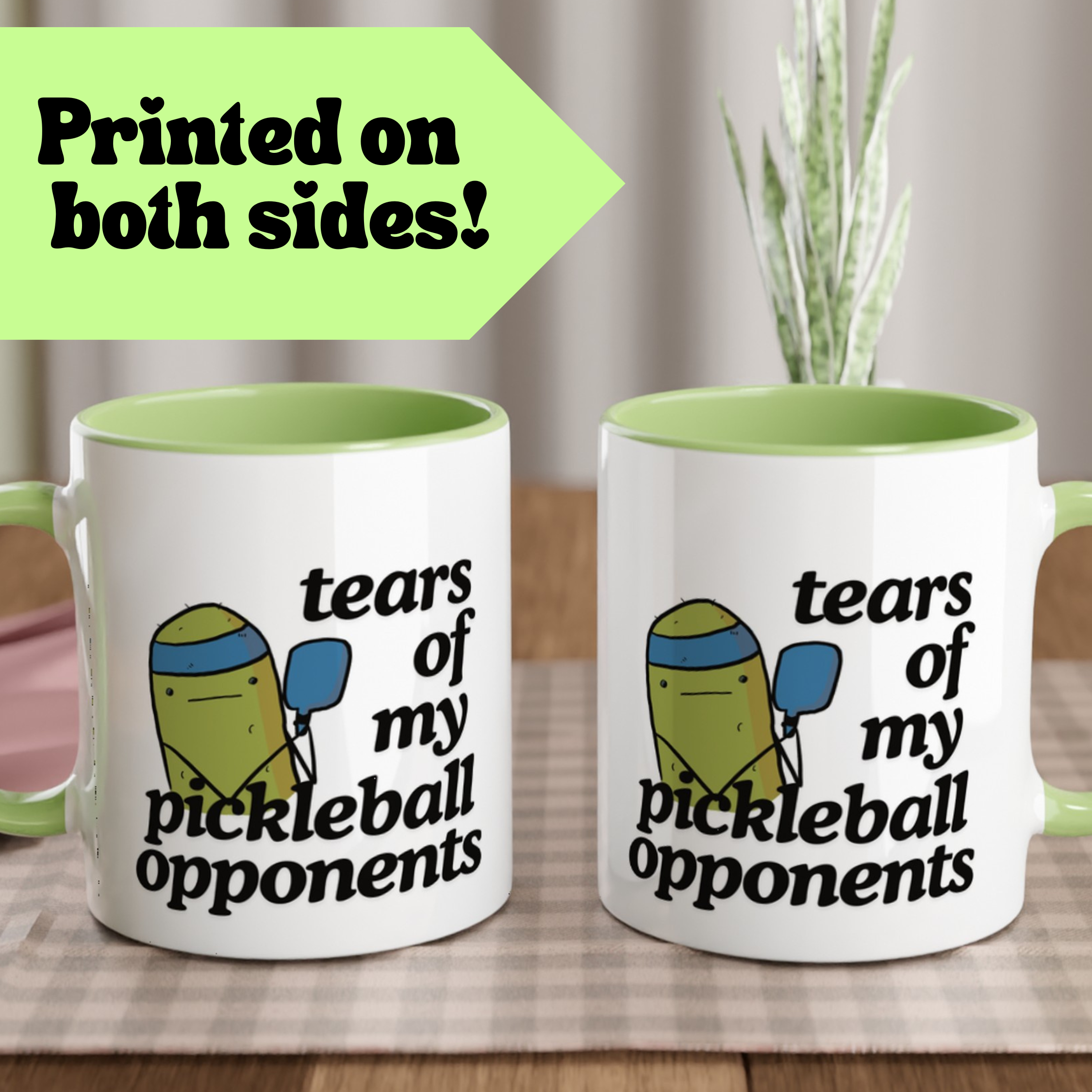 front view of a pickle ball mug with a funny quote that says "tears of my pickle ball opponents" with cute illustration of a pickle holding a blue pickle ball paddle