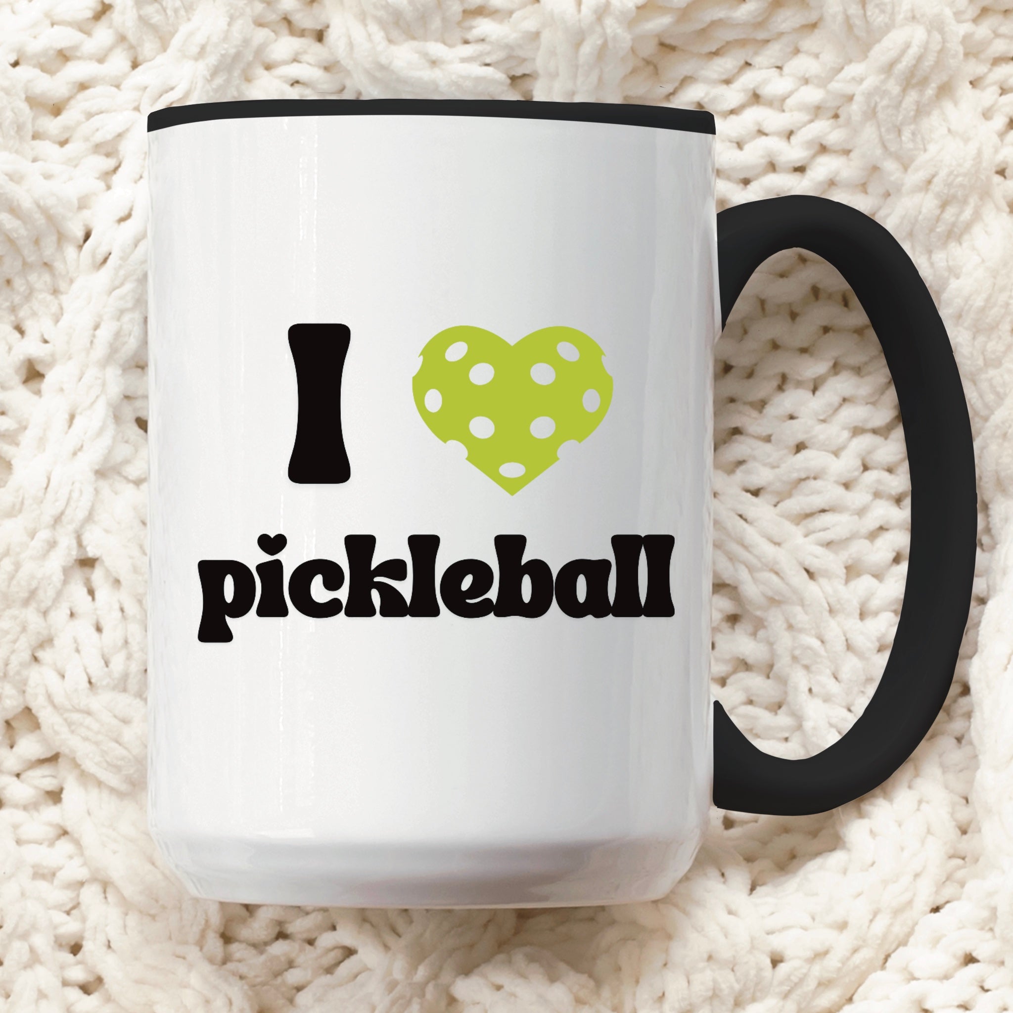 close up view of a pickle ball mug with a quote that says "I heart Pickle ball" with black ceramic accents