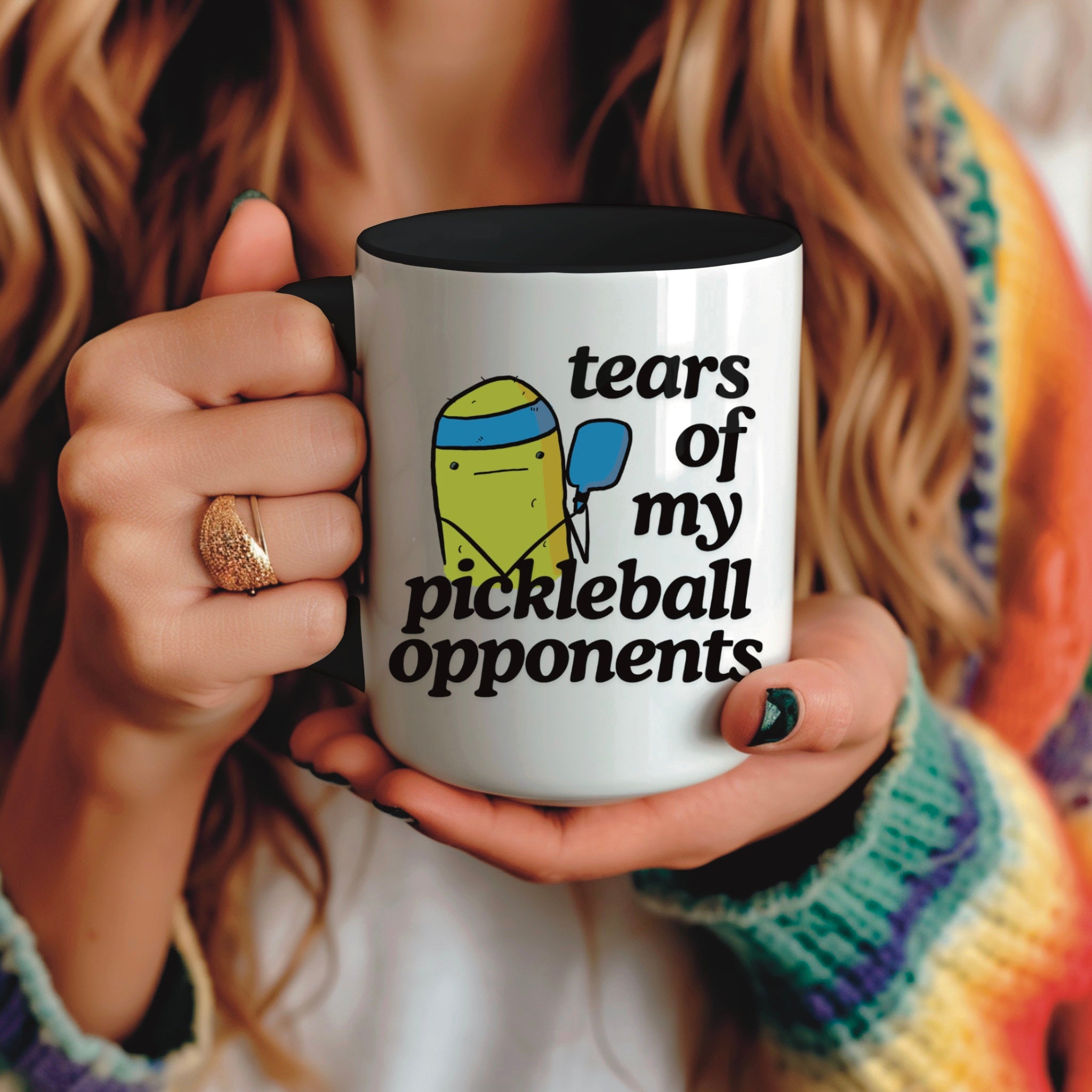 view of a woman holding a pickle ball mug with a funny quote that says "tears of my pickle ball opponents" with cute illustration of a pickle holding a blue pickle ball paddle