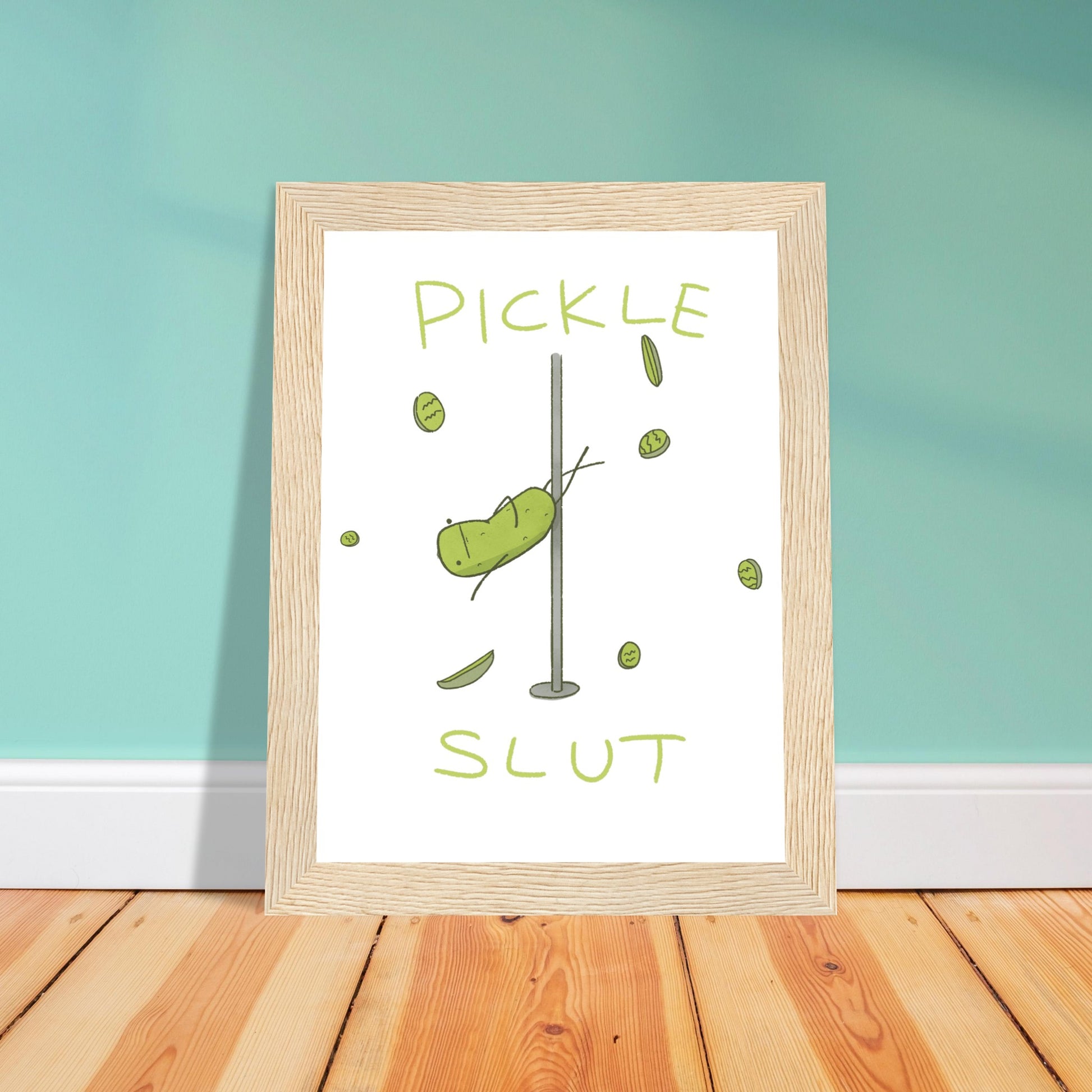 context view of wooden frame art print with funny design of pole dancing pickle with text that reads "pickle slut" below leaning against a wall