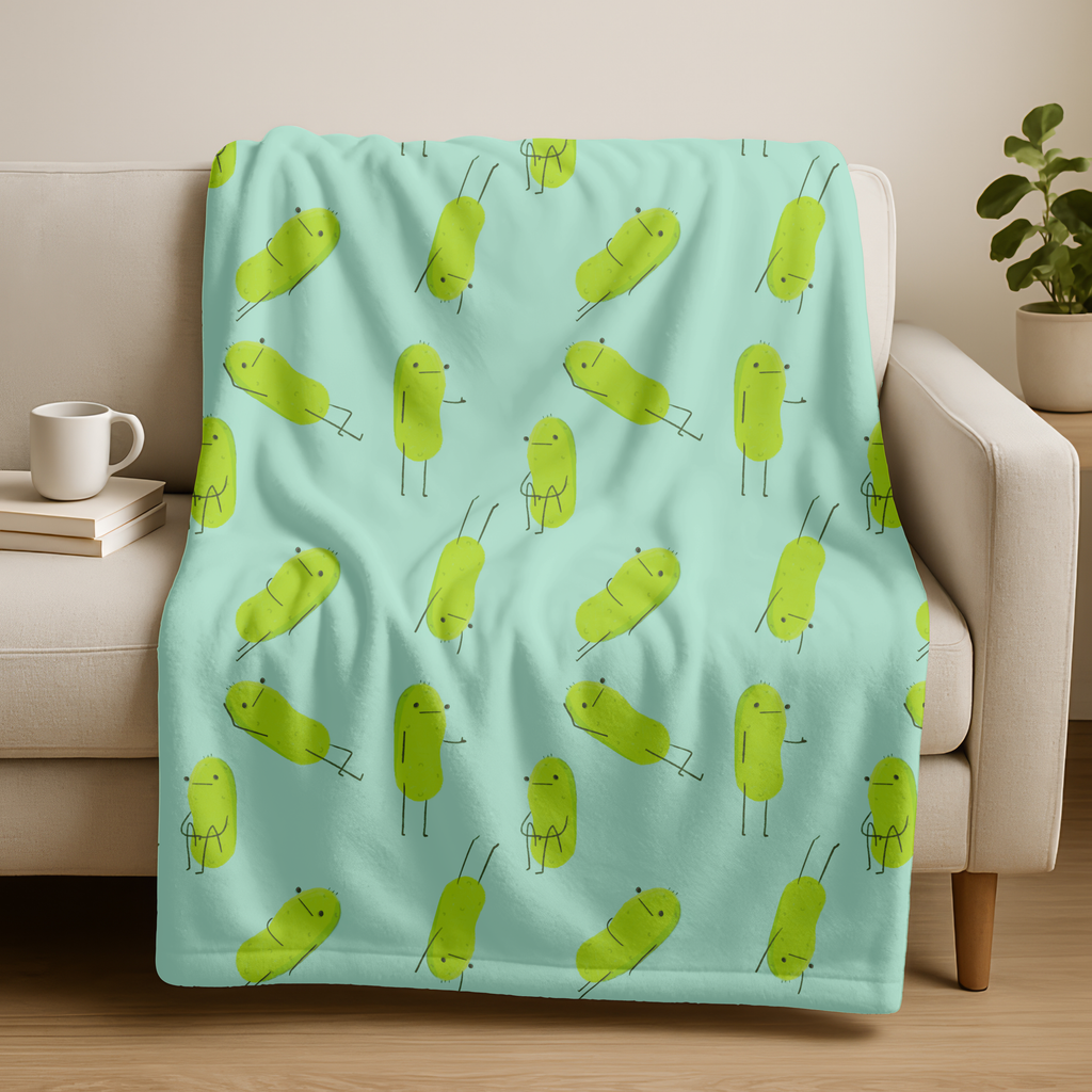 a light blue blanket with a cute pickle pattern is shown over a beige couch
