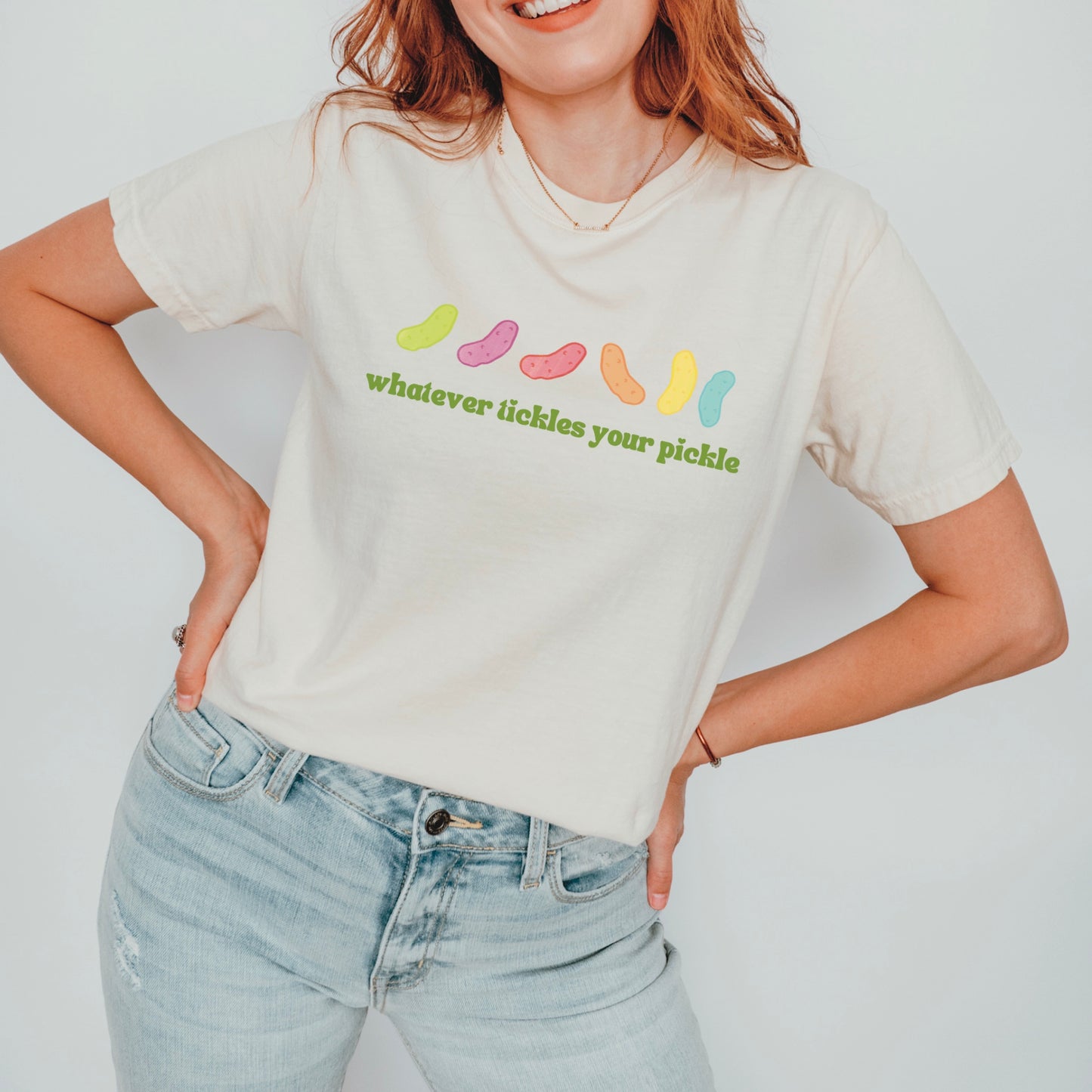 a woman wearing a pickle themed pride shirt with quote that says "whatever tickles your pickle"