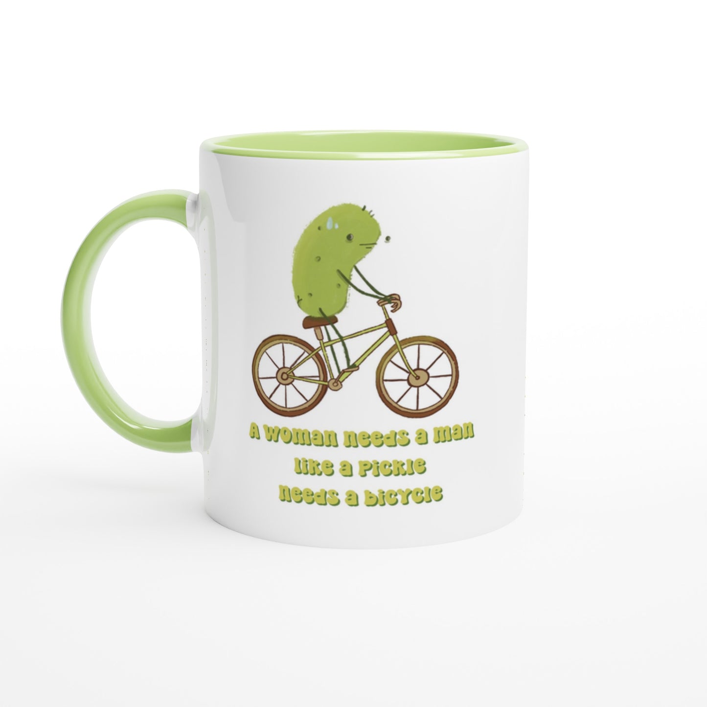 a feminist pickle mug featuring an illustration of a pickle on a bicycle and funny text that says "a woman needs a man like a pickle needs a bicycle" is displayed on a white background
