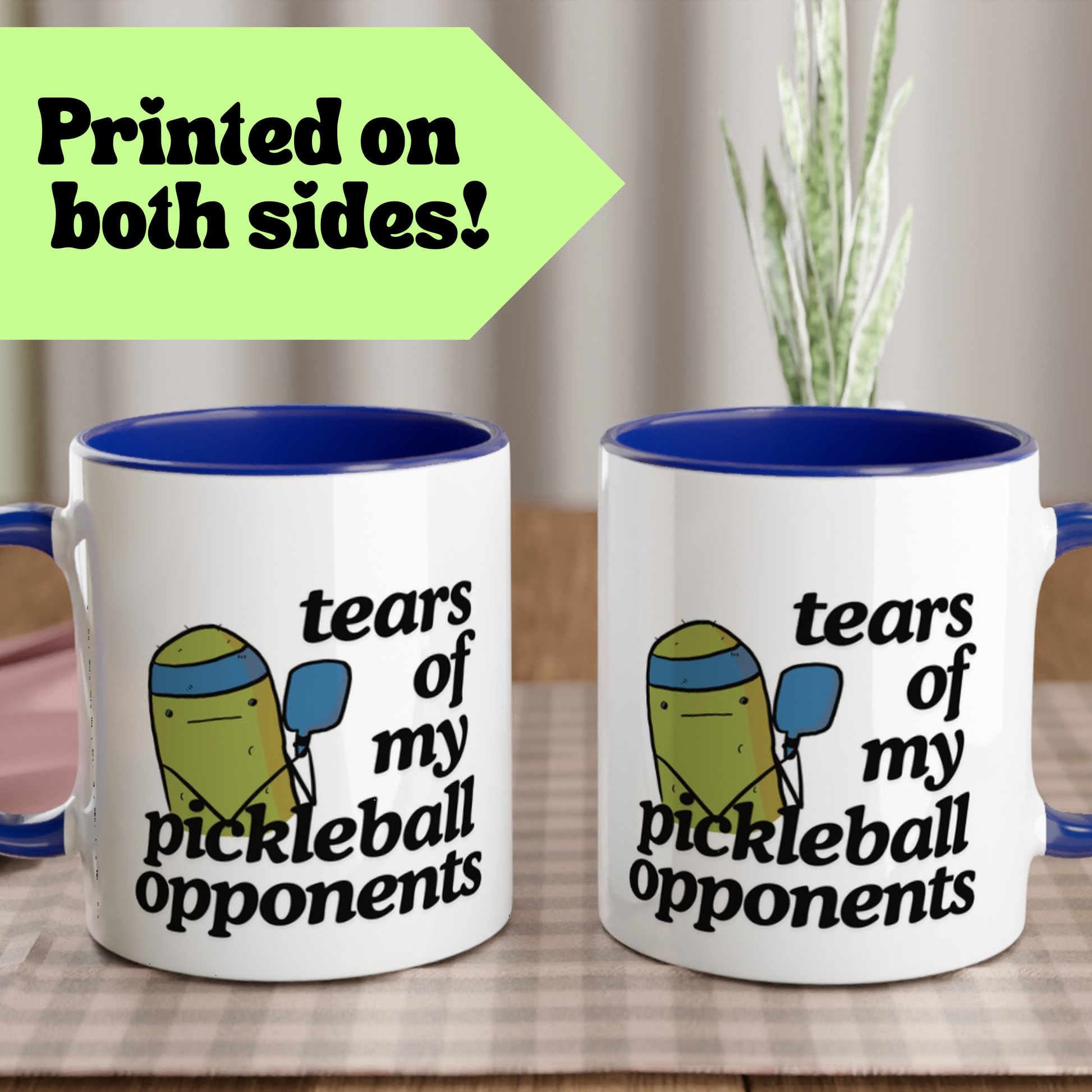 view of a pickleball mug with a quote that says "tears of my pickleball opponents" with cute illustration of a pickle holding a blue pickleball paddle