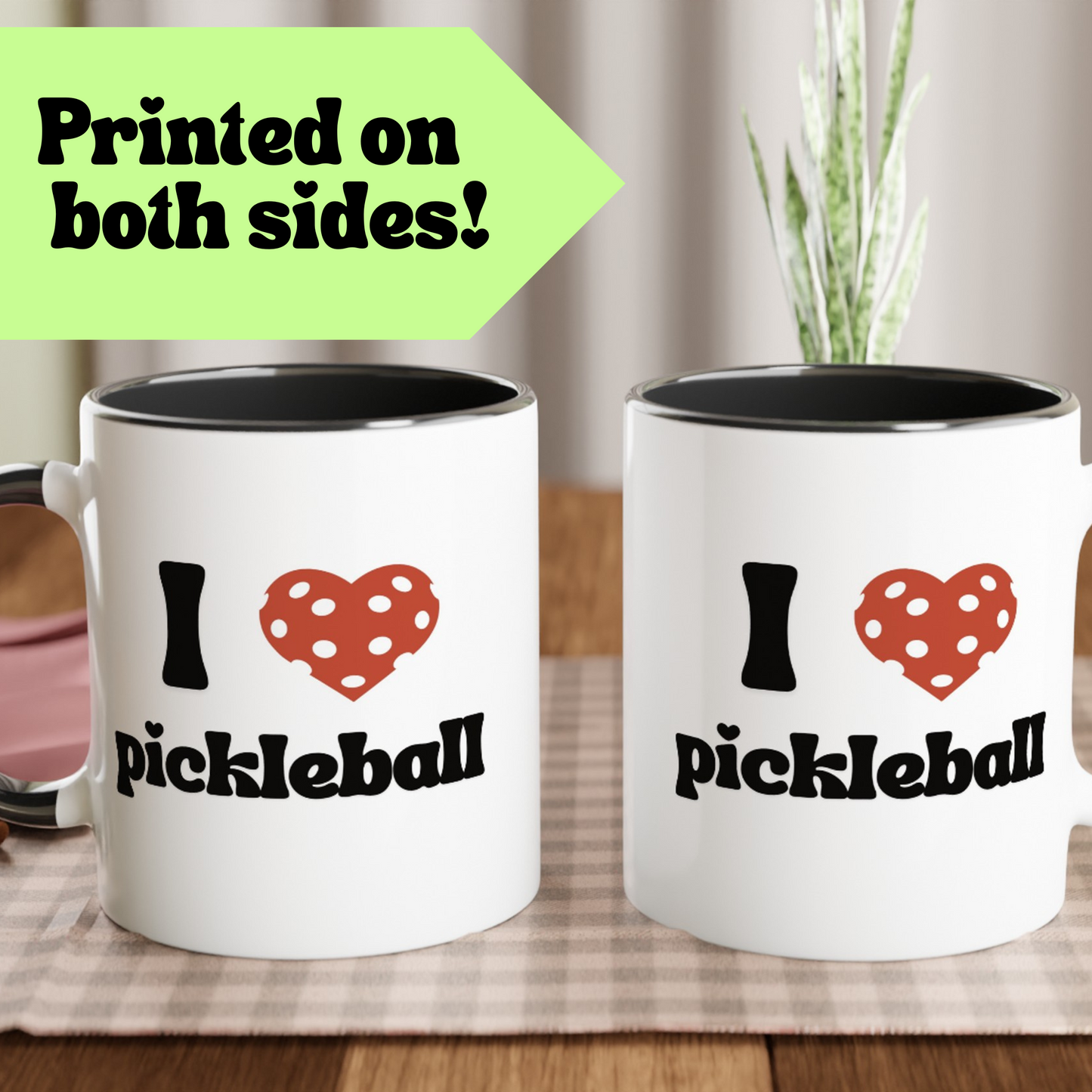 a pickle ball mug with a quote that says "I heart Pickle ball" with black ceramic accents is displayed in both front and back to indicate it is printed onto both sides