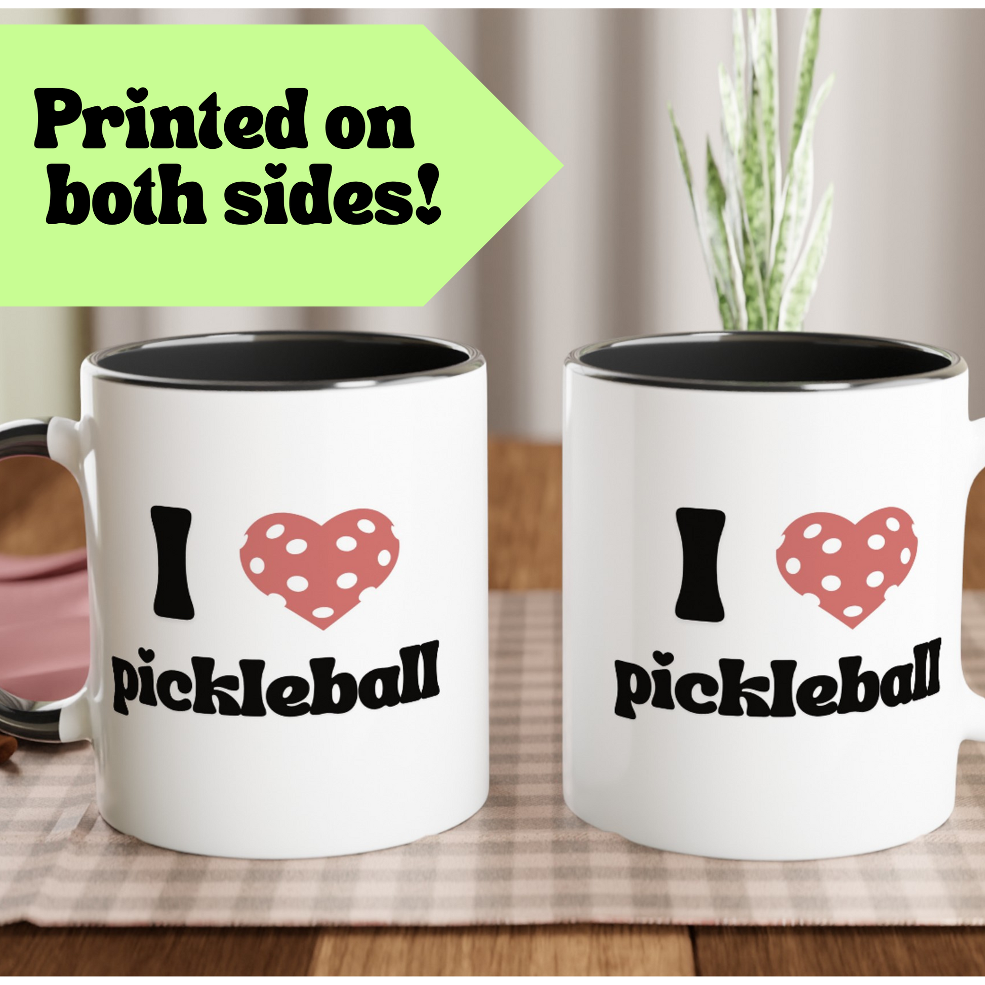 two sided view of a pickleball mug with a quote that says "I heart pickleball" with illustration of pink pickleball shaped heart with black ceramic accents