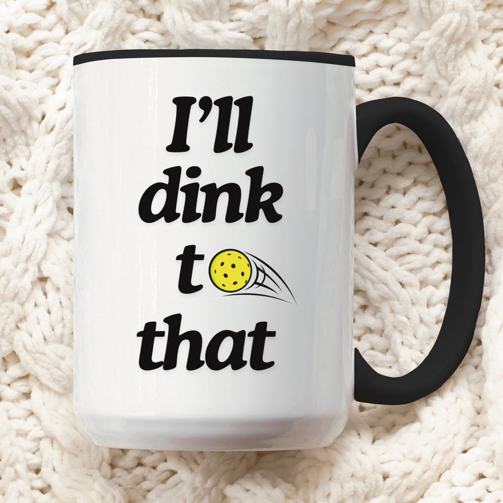 close up view of pickle ball mug with black ceramic accents and funny pickle ball quote that says "I'll dink to that"