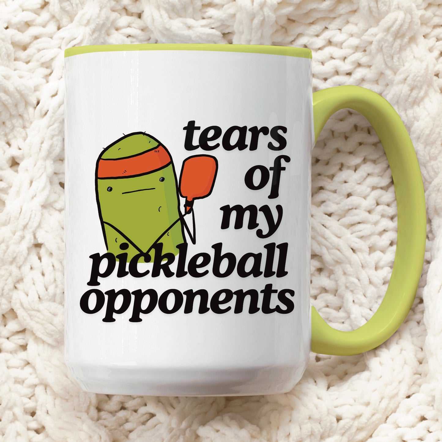 front view of a pickleball mug with a quote that says "tears of my pickleball opponents" with cute illustration of a pickle holding a red pickleball paddle