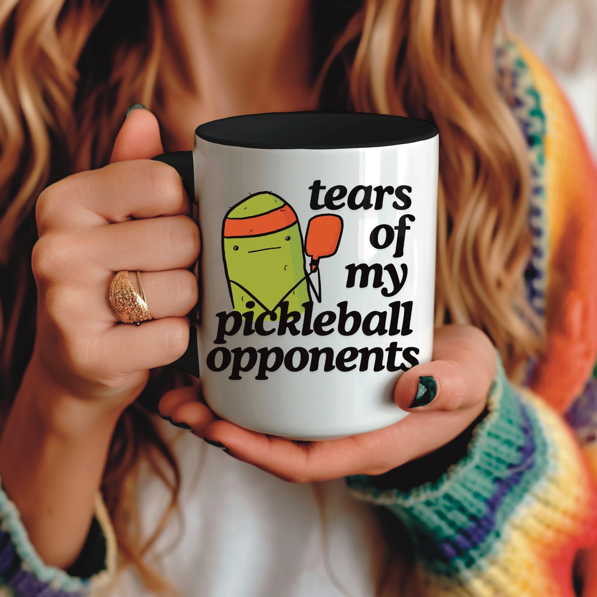 view of a woman holding a pickleball mug with a quote that says "tears of my pickleball opponents" with cute illustration of a pickle holding a red pickleball paddle