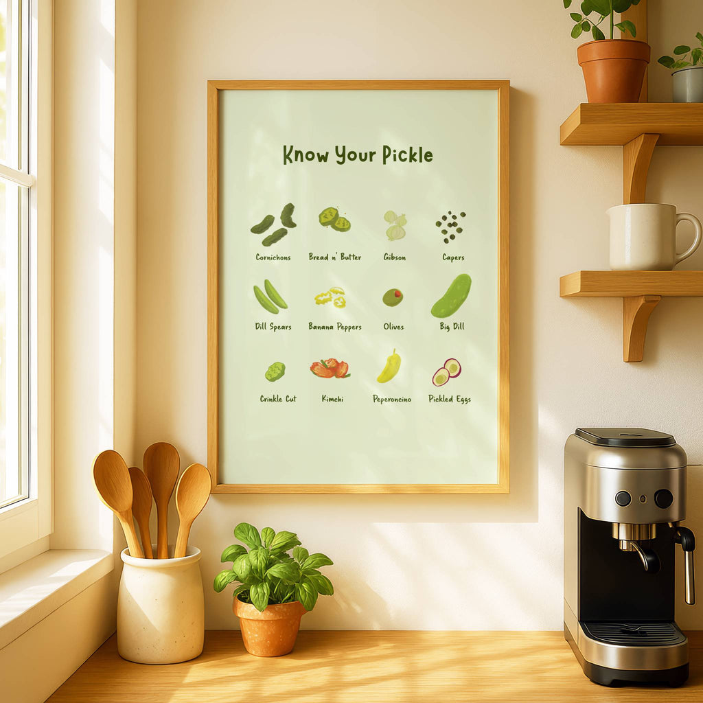 A pickle art print is displayed on a kitchen wall next to a window and an espresso machine